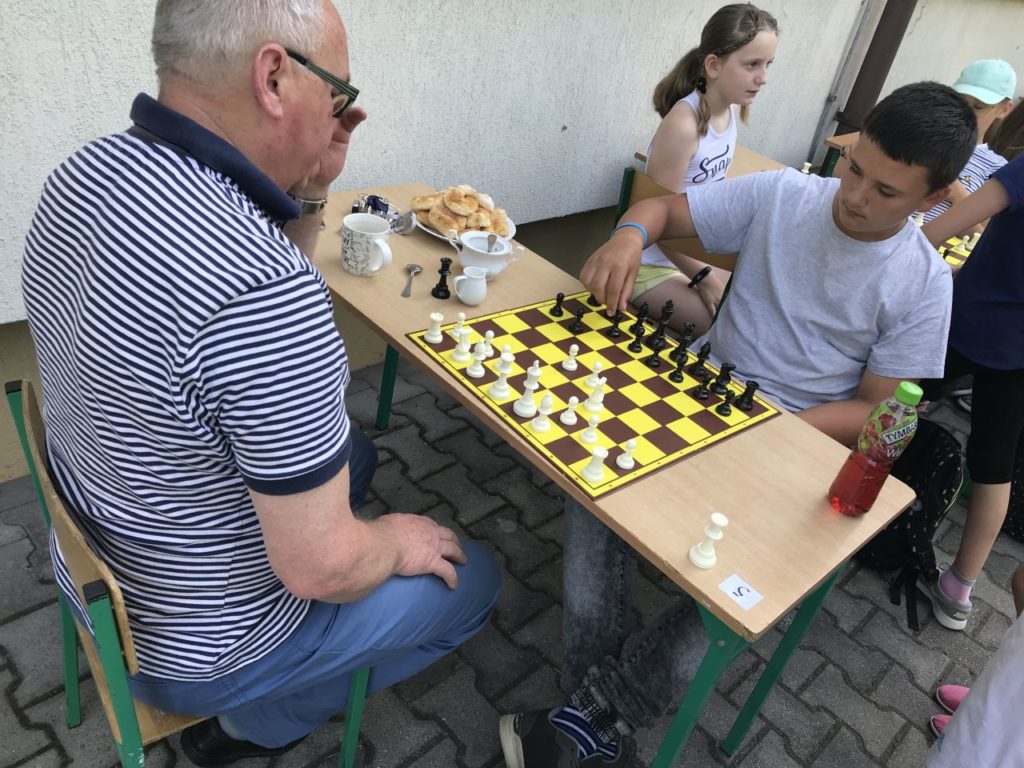 Uczesnicy turnieju szachowego Myśl i graj przed budynkiem filii biblioteki w Kamionce Wielkiej.