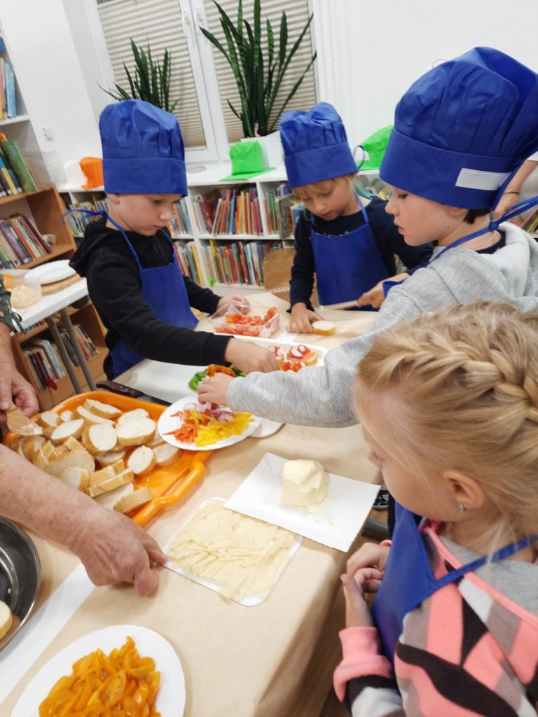 Dzieci uczestniczące w warsztatach kulinarnych.